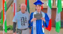 TMCC alumni Noritaka Miyamoto holds a diploma at his graduation ceremony.