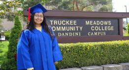 TMCC graduate Daisy Villa in front of a TMCC sign on campus.