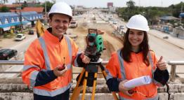 College students working with a geospatial data management tool at a construction site.