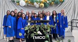 Nursing graduates pose for a picture on the stage inside the Student Center with instructors.